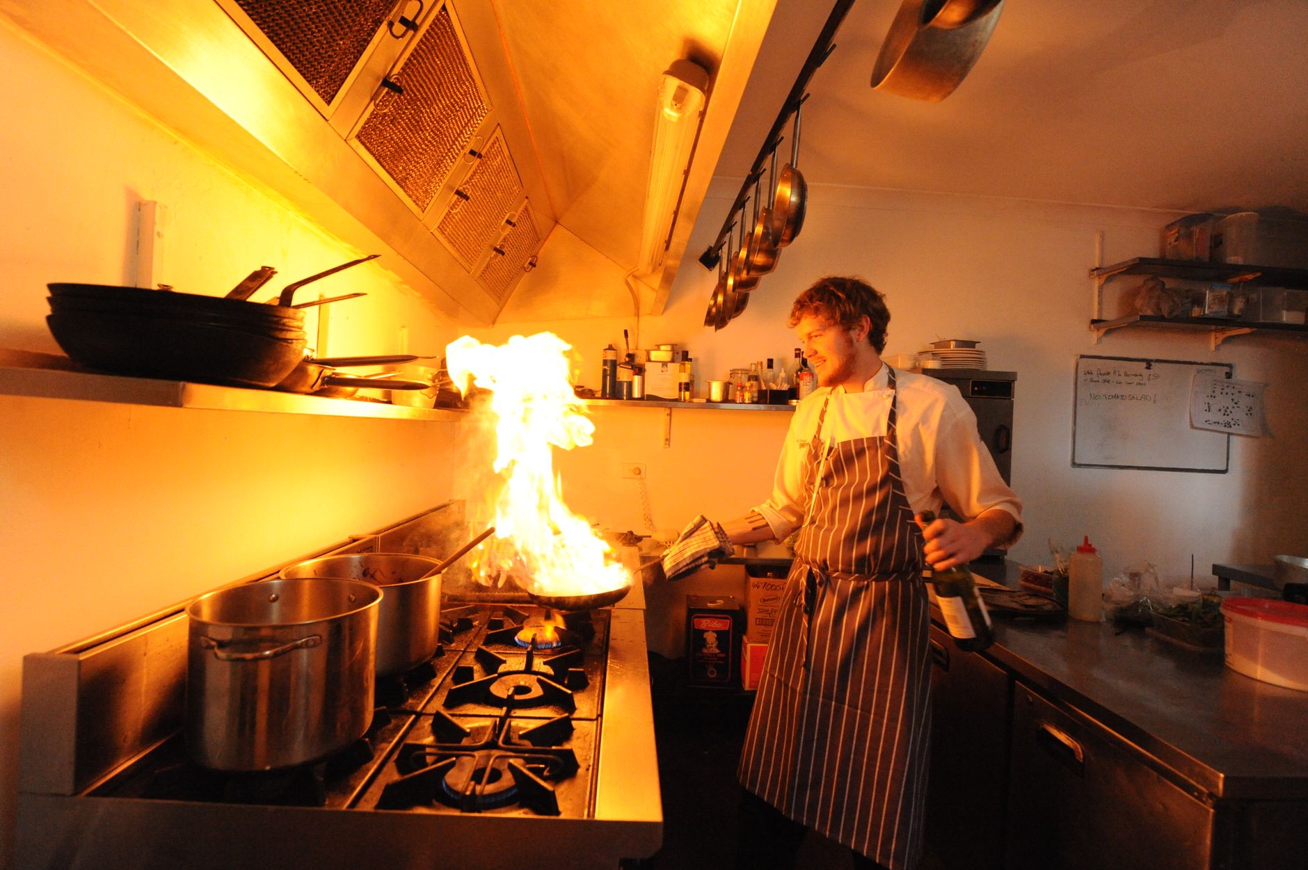 chef flambeing dish in professional kitchen