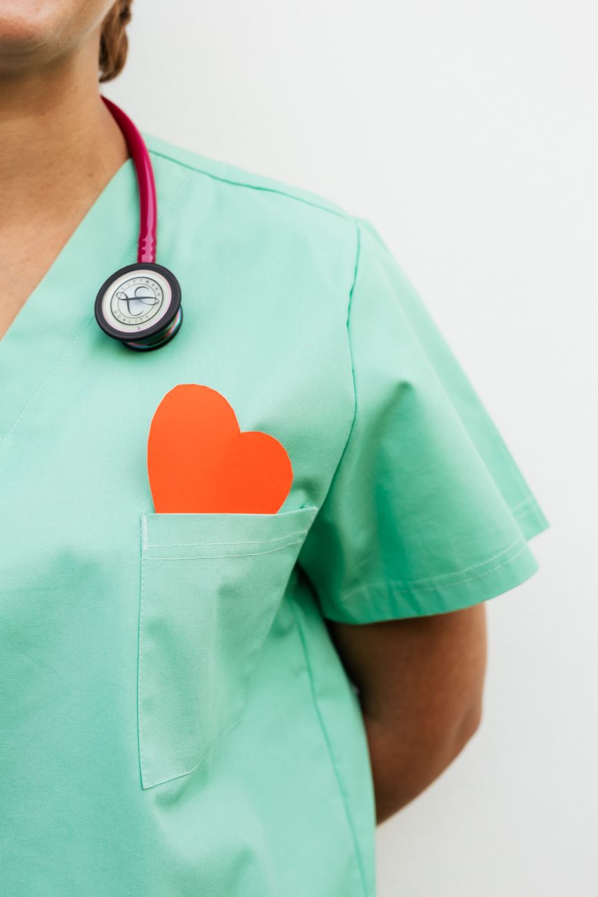 person wearing scrub suit with paper heart in the pocket