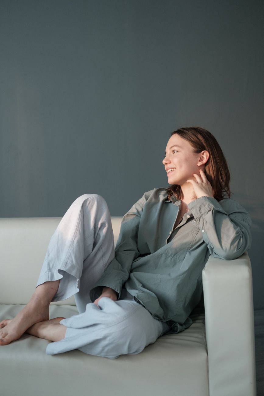 smiling woman sitting on couch with legs crossed