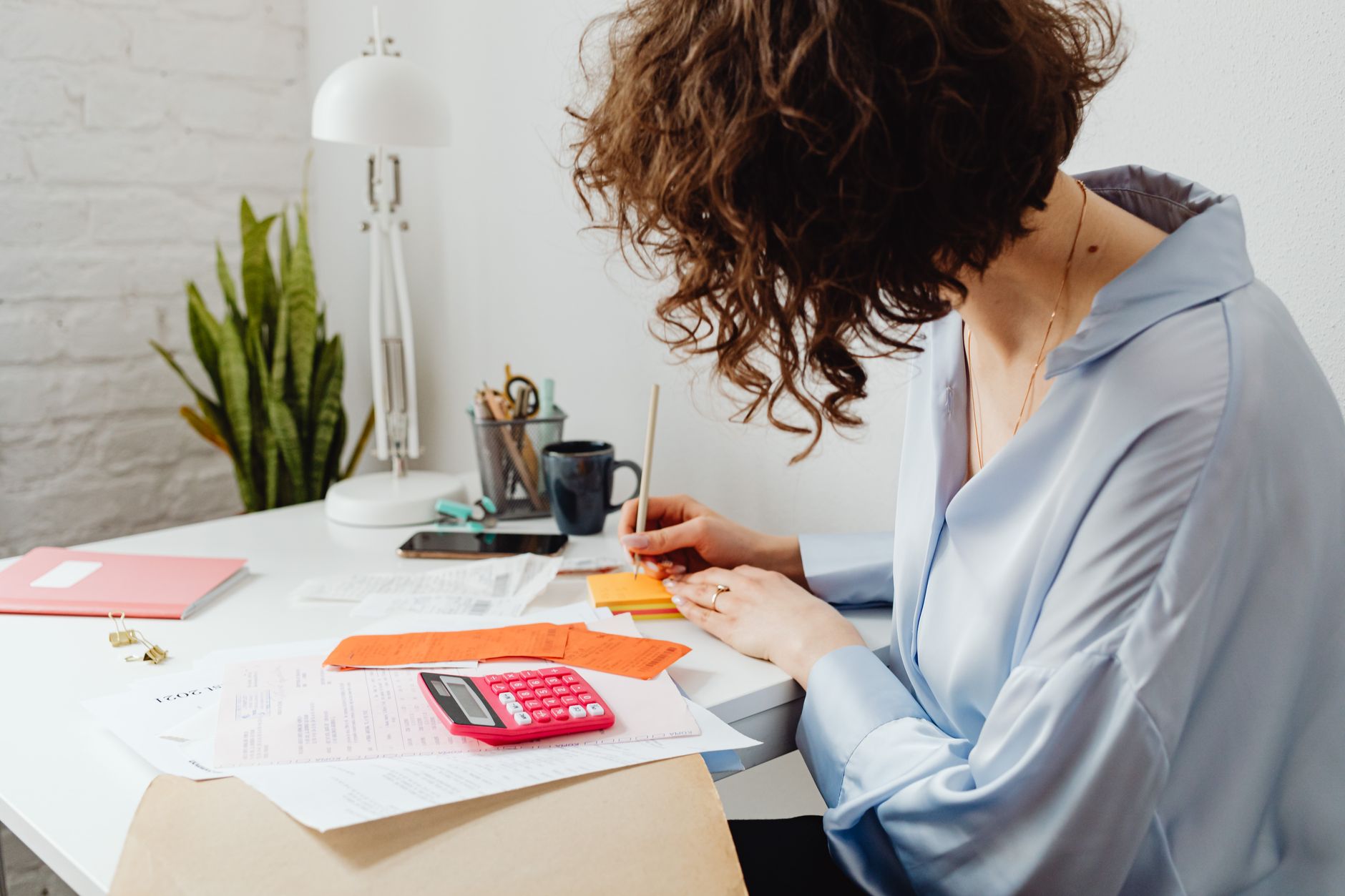 a woman writing on a sticky note