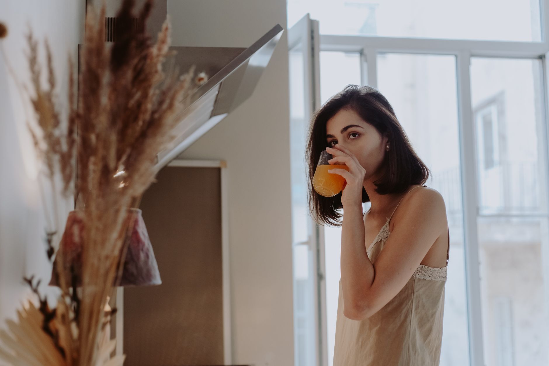 a woman drinking juice from a glass