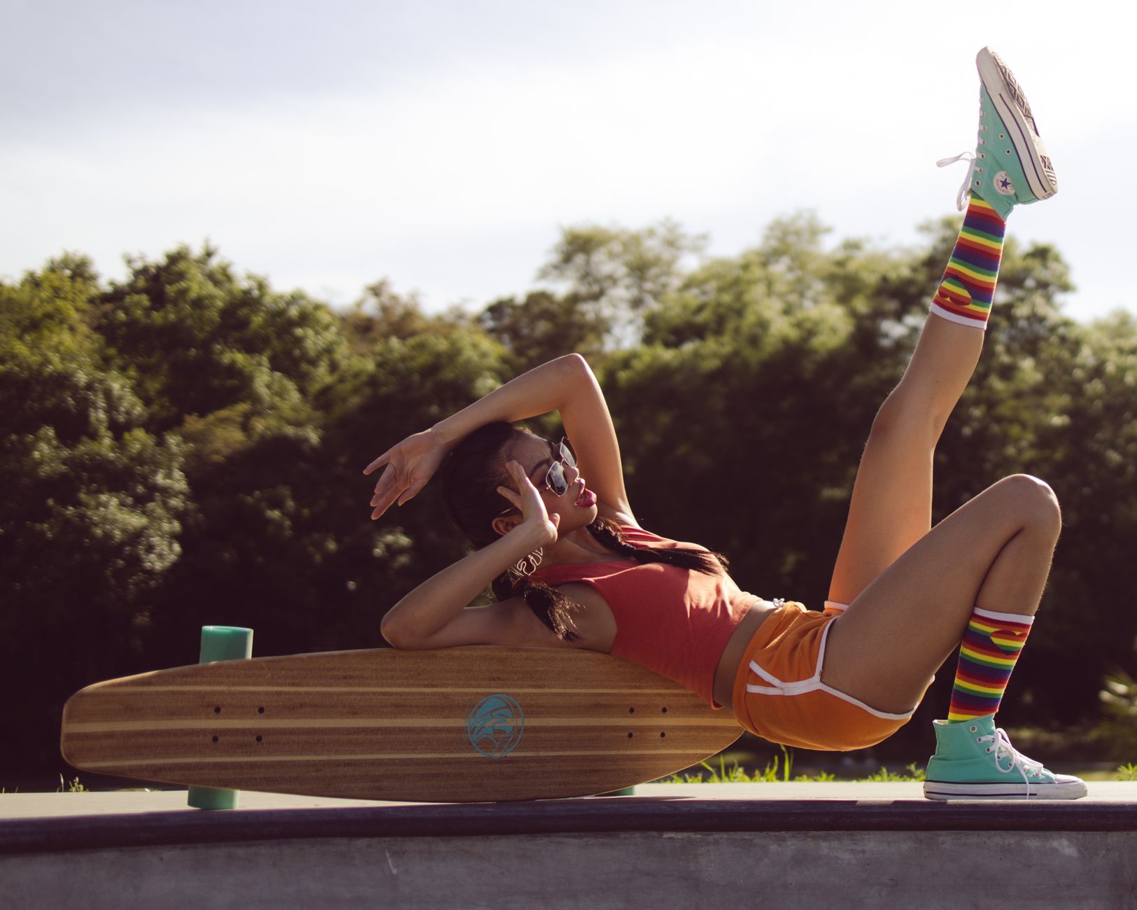 a woman in sportswear lying on brown wooden skateboard