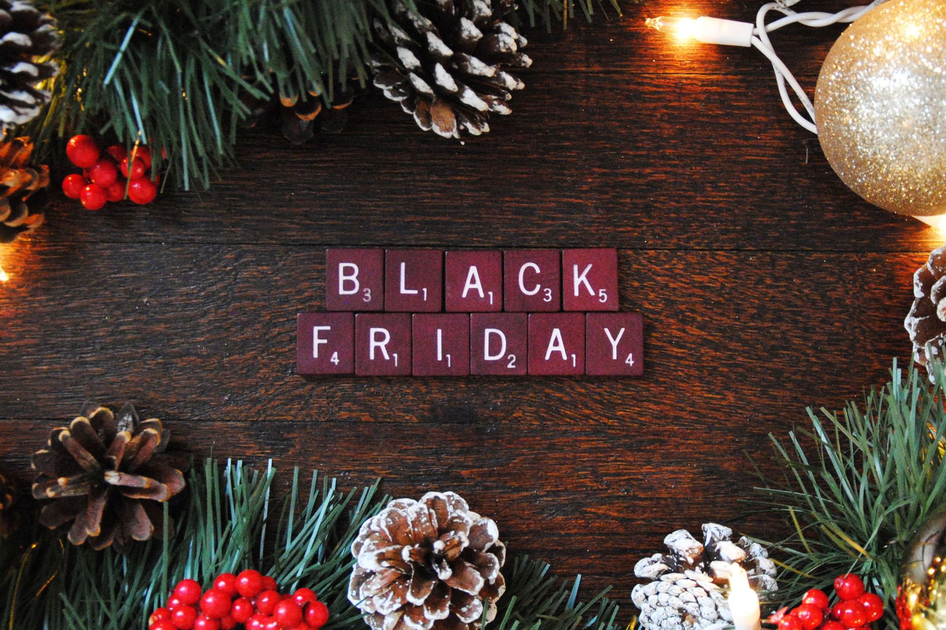 sign black friday made from letter tiles lying on a wooden surface among christmas decorations
