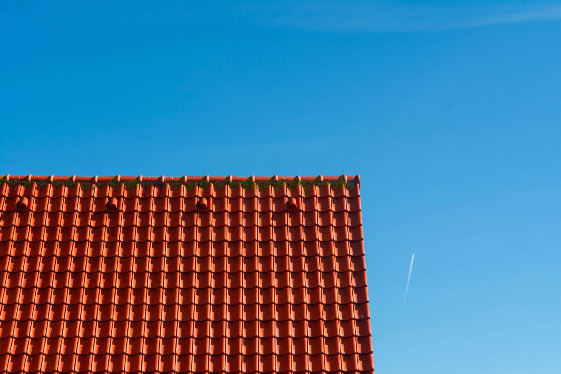 roof with red tiles on the background of clear blue sky