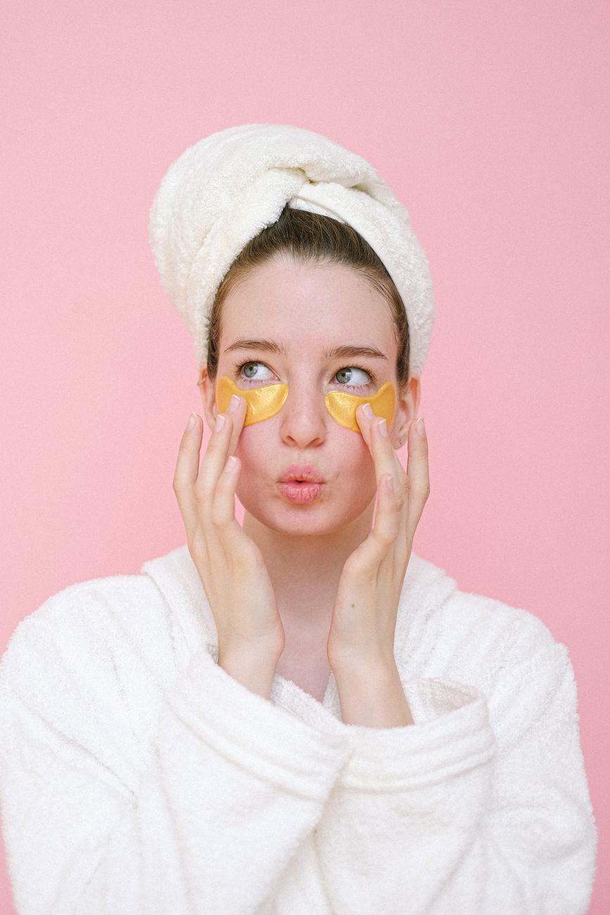 woman with eye patches touching face and pouting lips