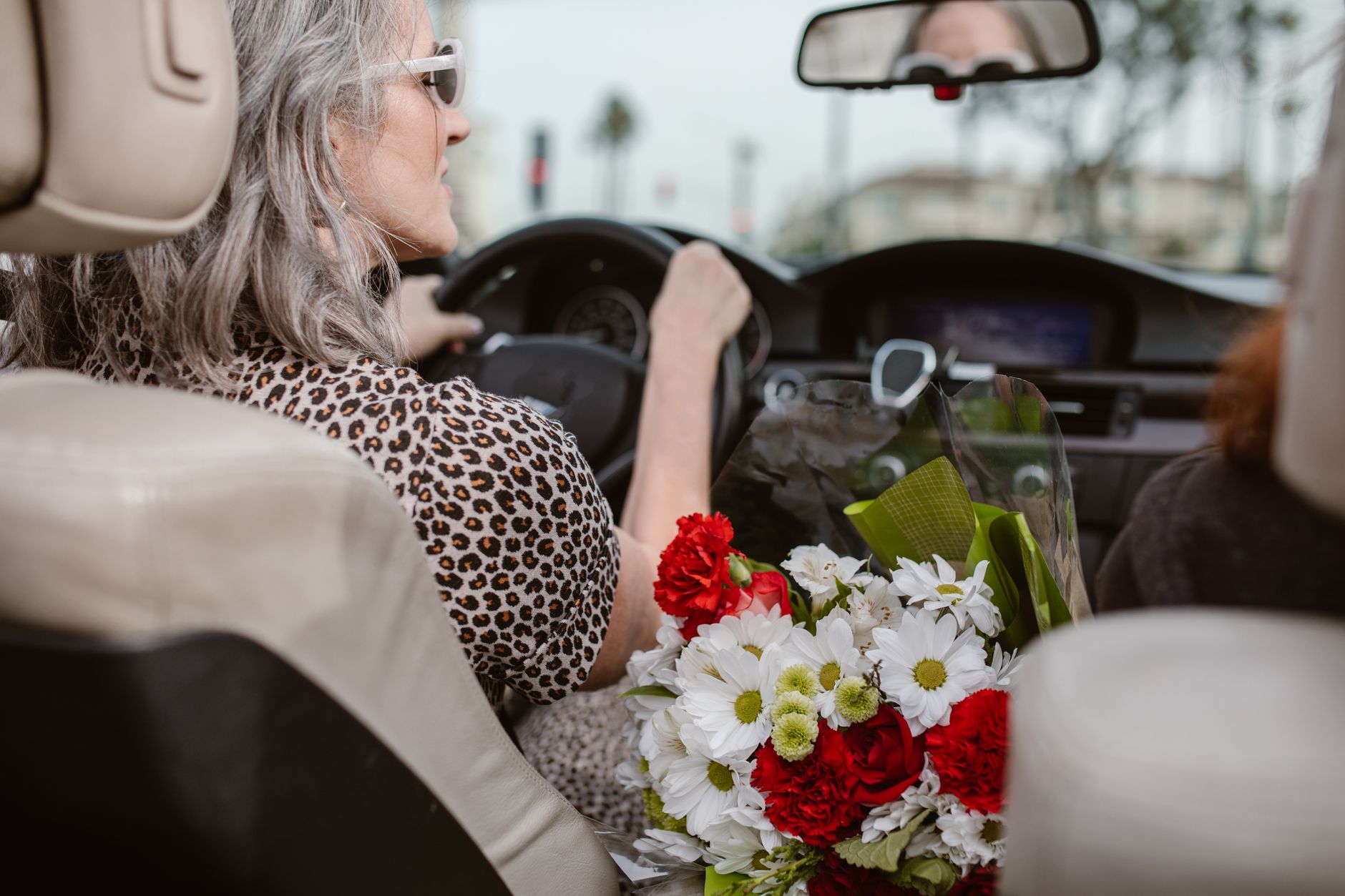 a woman in leopard print top driving a car