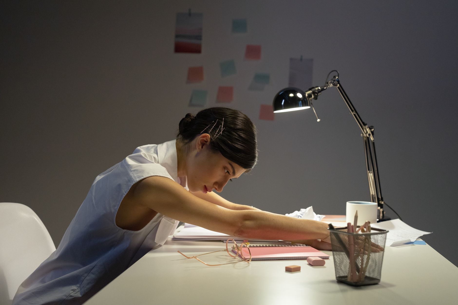 female office worker stretching on top of her desk